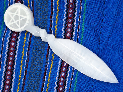 A selenite athame knife with a pentacle symbol on top with beautiful background.