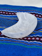Load image into Gallery viewer, A Selenite Bowl Crescent Moon Shaped holds white quartz stone serene white background.
