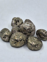 Load image into Gallery viewer, A pyrite geode with eight tumbled stones on white background.
