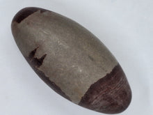 Load image into Gallery viewer, Smooth round narmada shiva lingam egg with brown and black stripes.
