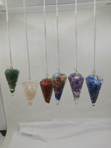 On a serene white background, a stunning assortment of 7-color Orgonite Pendulums gracefully hangs from a silver chain.