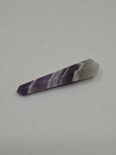 A natural chevron amethyst double terminated points stone on a serene white background.