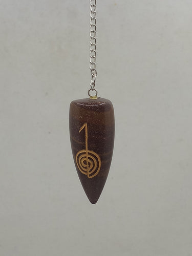 A Narmada lingam-shaped reiki sign engraved pendulum elegantly hangs from a silver chain.