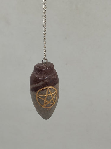 A Narmada lingam-shaped pentagram engraved pendulum elegantly hangs from a silver chain on a serene white background.