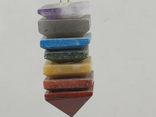 A beautiful 7-colour Chakra Stones Pyramid Bonded Pendulum on a serene white background.