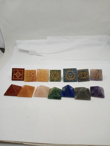 A set of seven chakra pyramids engraved reiki signs at the base arranged in a row with different color.