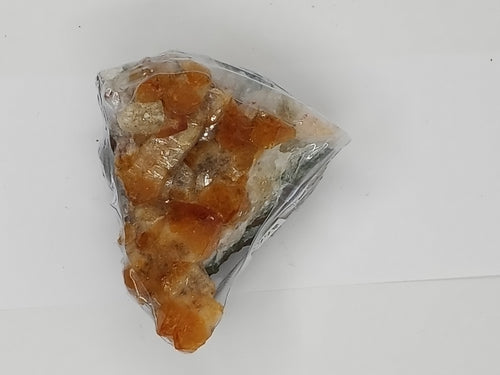 A natural citrine cluster crystal on serene white surface.