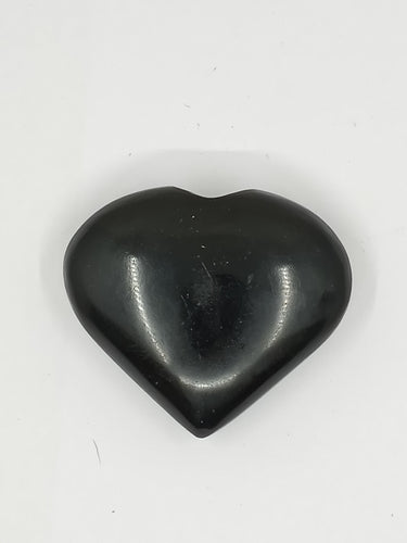 An obsidian black puffy heart stone on a white background