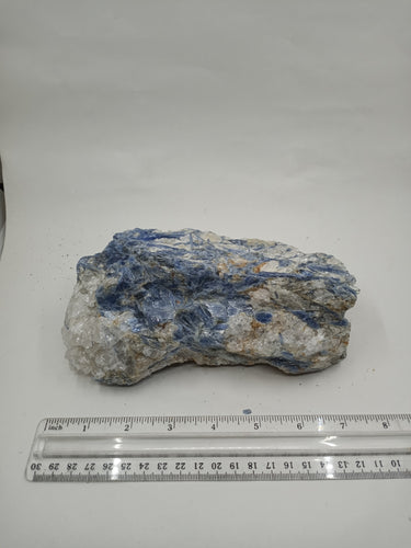 A natural blue kyanite chunk crystal is unevenly shaped with scale on serene white surface.